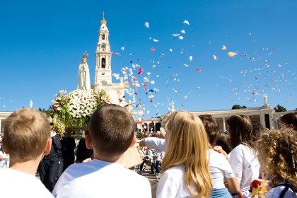 Mit Blütenblättern grüßen Pilger die Marienstatue in Fátima, Portugal, © anturio daSanturio de Fátimae Fátima